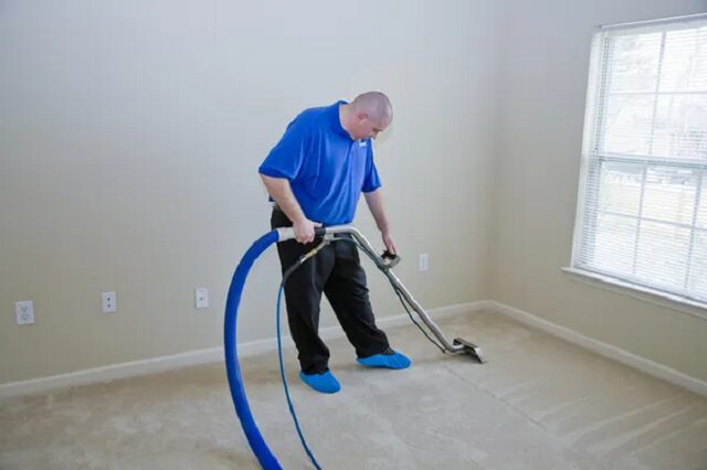  un homme utilisant un nettoyeur vapeur pour tapis